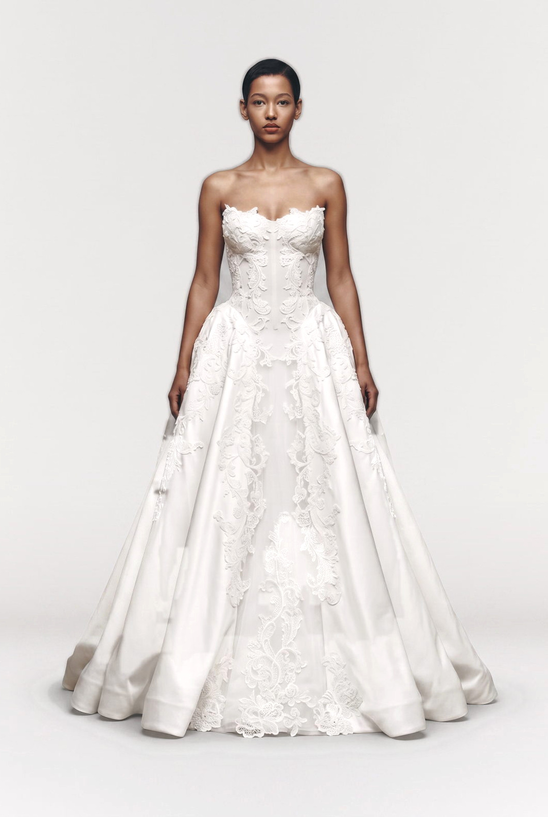 Bride in a strapless lace appliqué ball gown, full figure studio shot